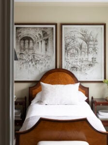 Antique bed with oversized charcoal artwork against beige wall