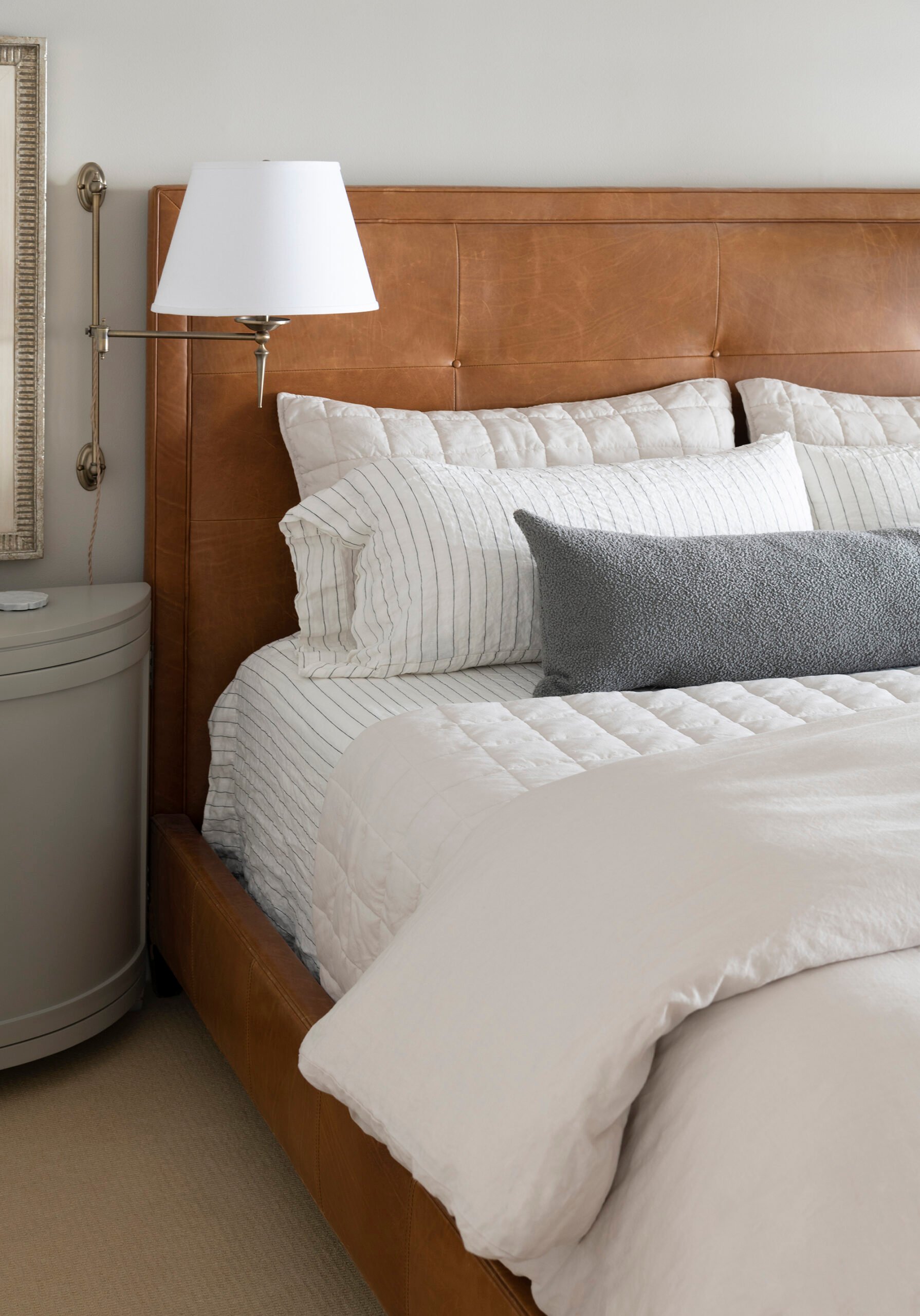 Classic leather bed with box tufting and linen bedding