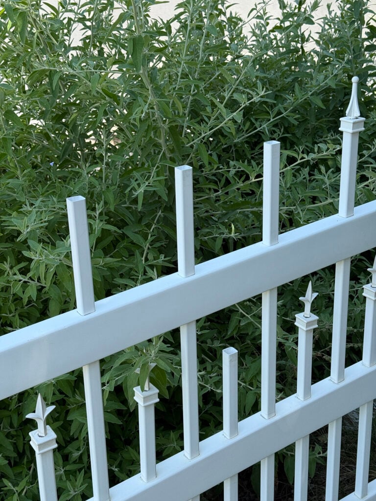 Before image of a white vinyl fence post with missing finials or post caps that is dirty and ugly.