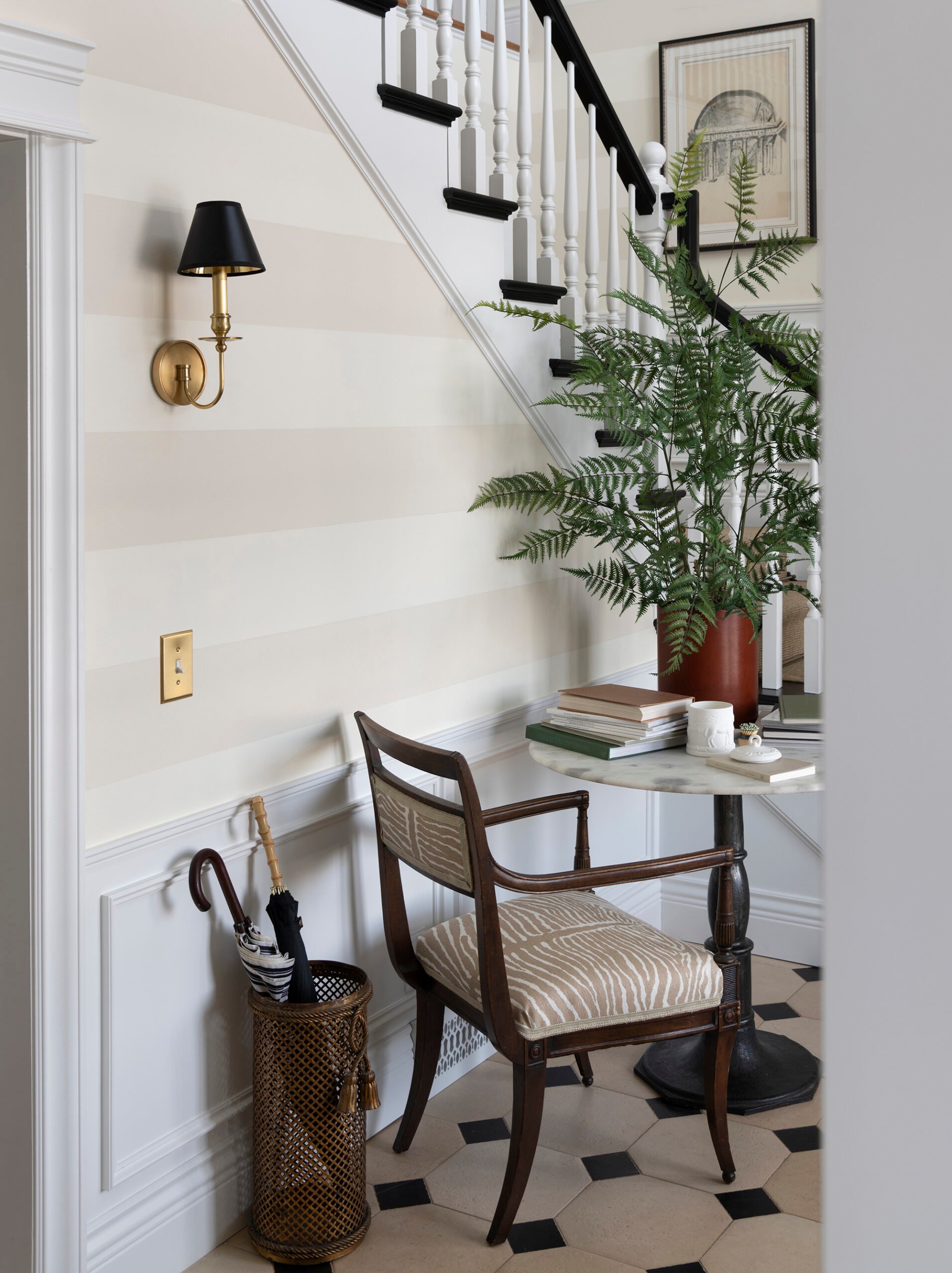 Limestone tiled foyer with marble table, antique chair, and large fern
