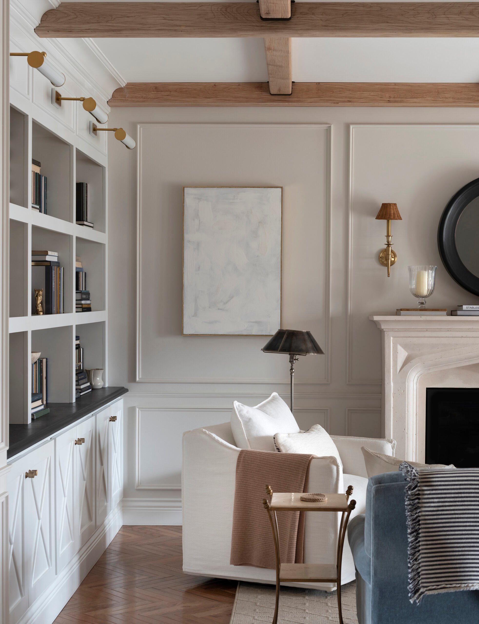 Living room with white swivel chairs, beams, and built-in bookcase