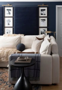Navy media room with large sectional, acoustic wall panels, and vintage ski art