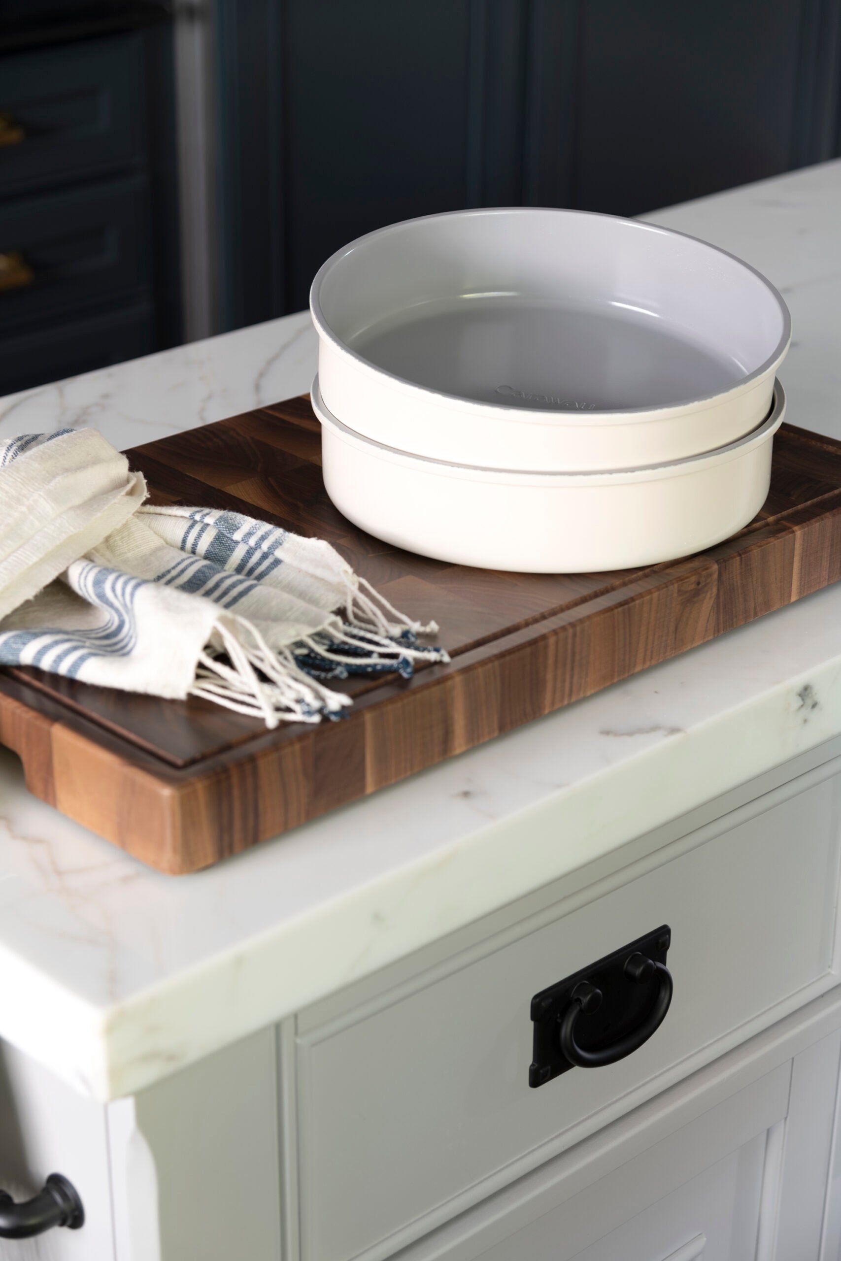 Two round nonstick Caraway cake pans on a marble kitchen island