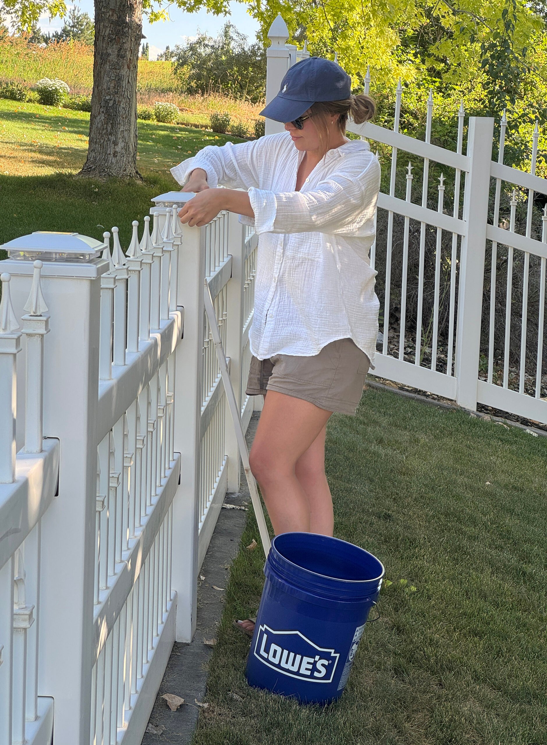 Repairing vinyl fence posts, replacing finials and post caps, and installing solar fence post lighting in backyard with Lowe's bucket