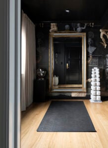 Roman wallpaper in black modenr home gym with gilded mirror