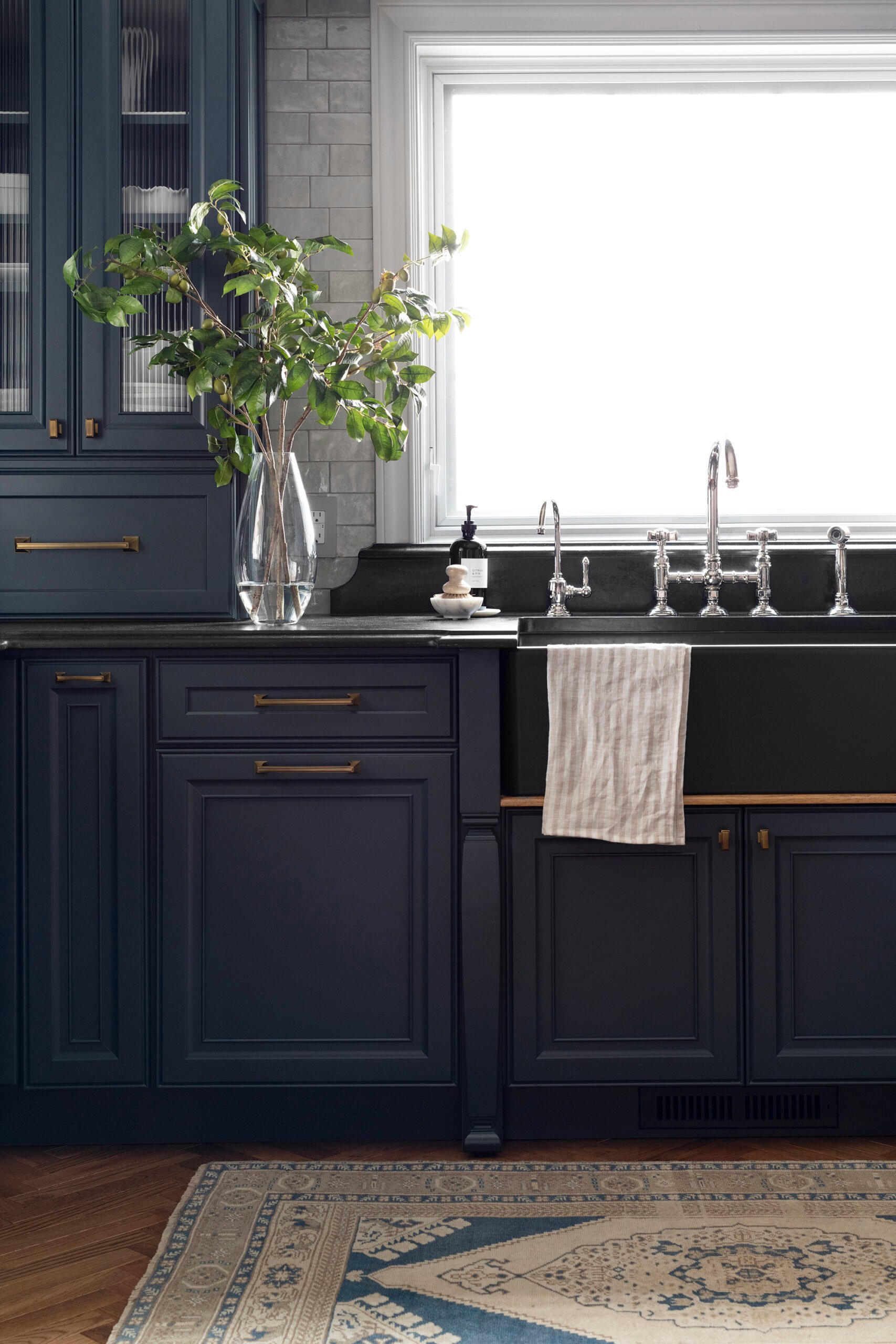 Soapstone Countertop in Kitchen with Dark Navy Cabinets and a Vintage Rug in Front of the Sink
